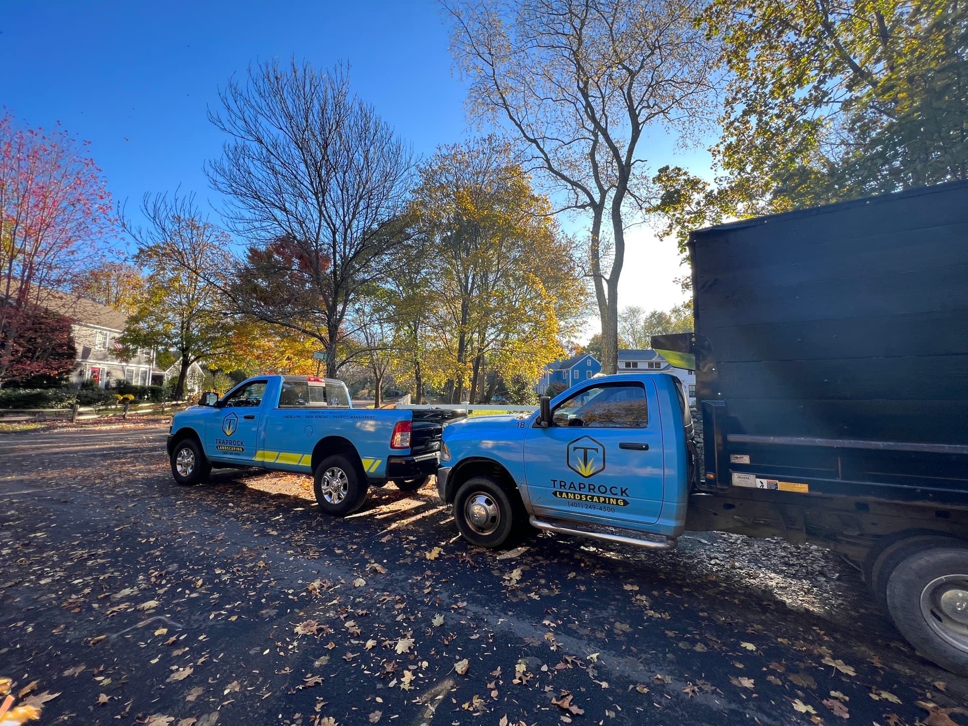 Professional gutter service trucks in fall setting